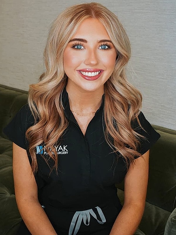 Smiling woman in black uniform, professional setting.