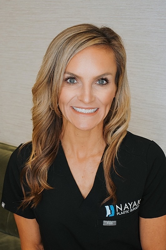 Smiling healthcare professional in black scrubs.