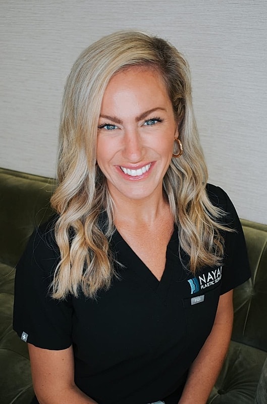 Smiling woman in professional medical attire.
