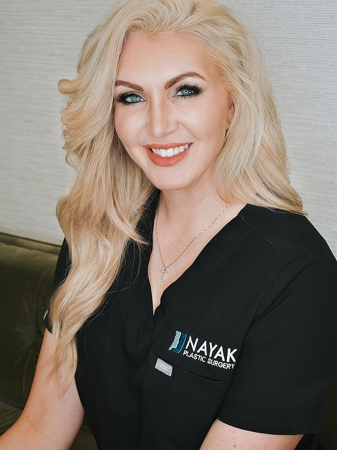 Smiling professional in medical attire at clinic.