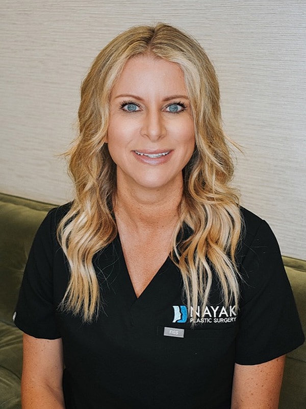 Female medical professional smiling in professional attire.