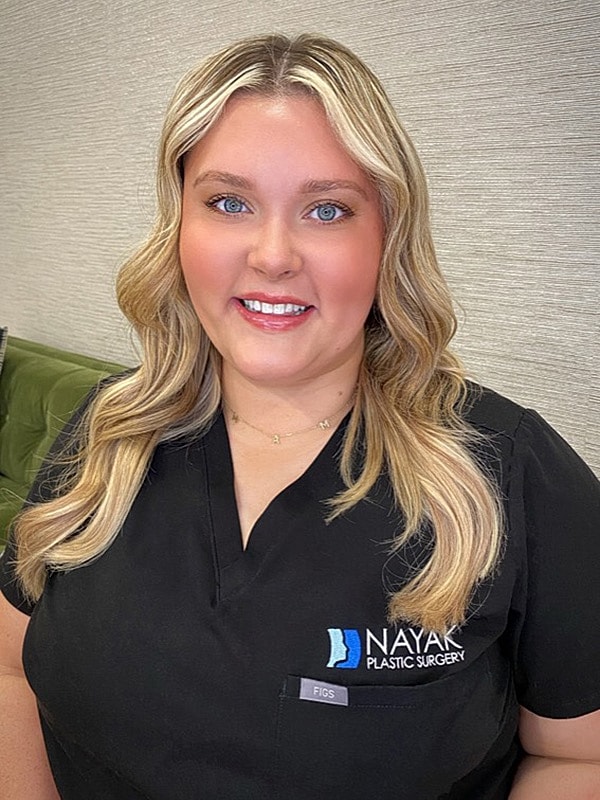 Woman in scrubs at plastic surgery clinic.