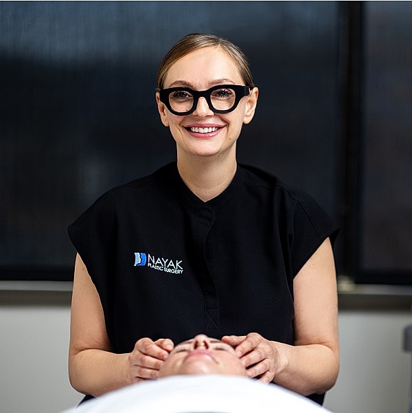 Smiling St. Louis Med Spa provider performing treatment on client.
