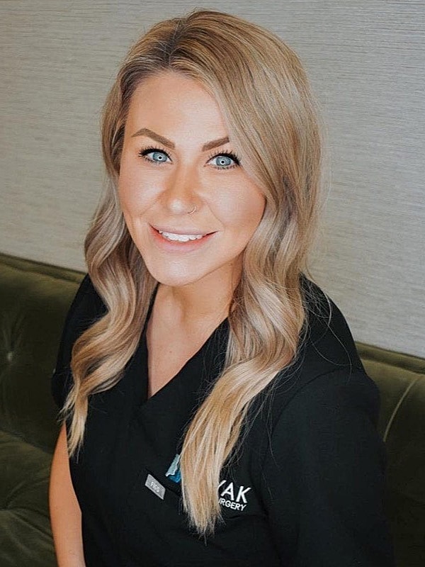 Smiling woman in medical uniform, professional setting.