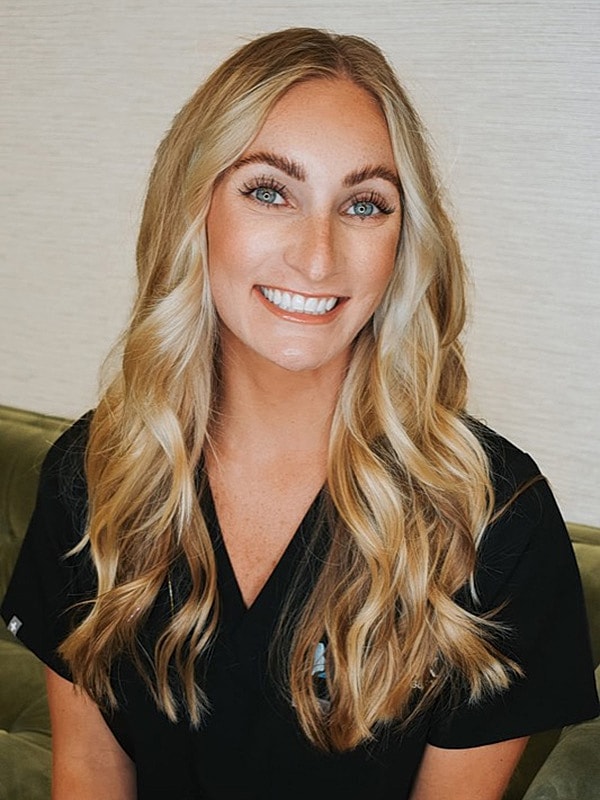 Smiling woman with long blonde hair in scrubs.