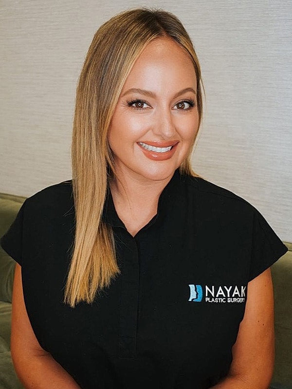 Woman smiling in a plastic surgery office.