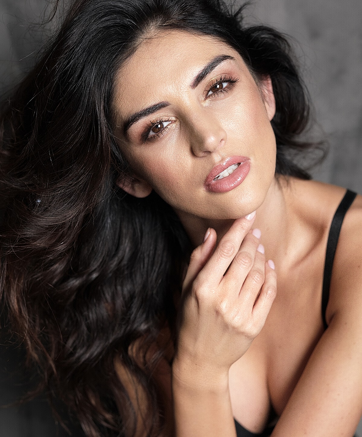 St. Louis injectables model with wavy dark hair.