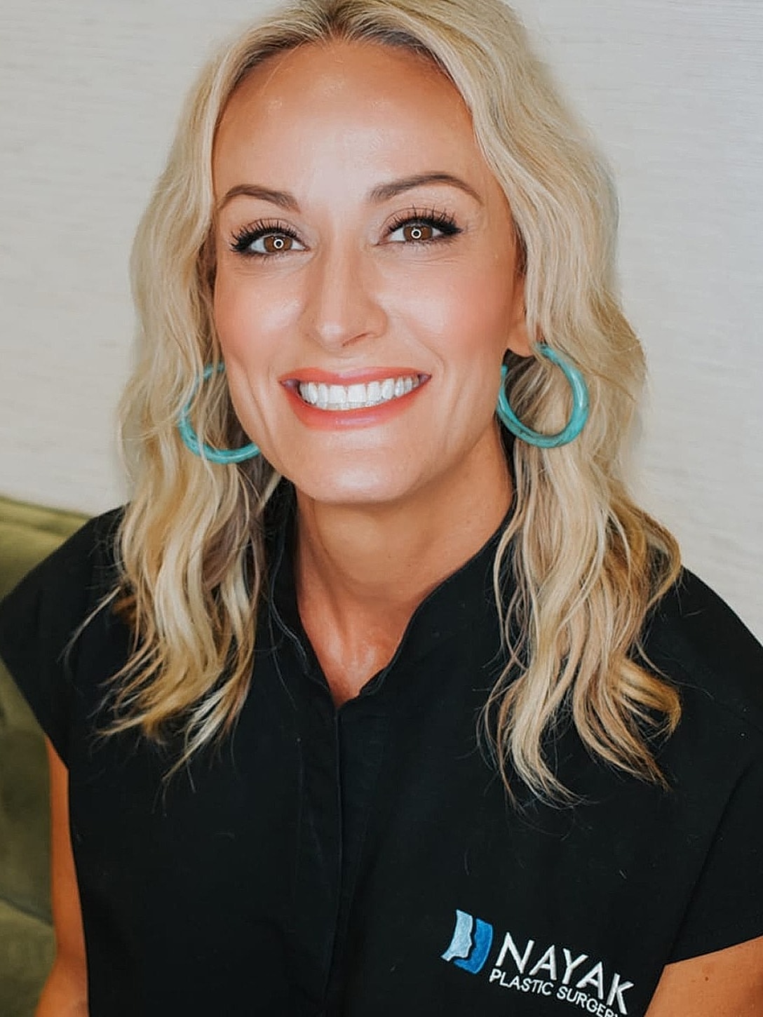 Smiling woman in professional attire, blonde hair.