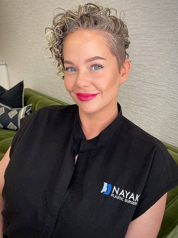 Female professional with short curly hair smiling.
