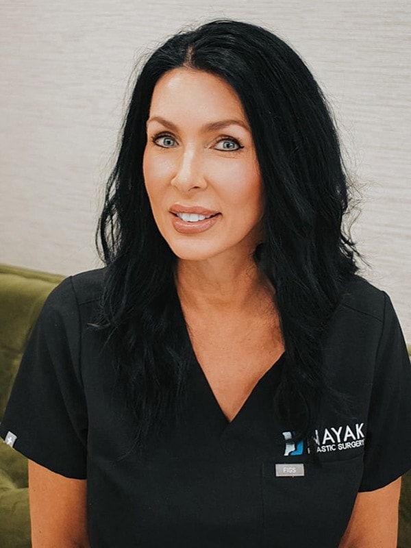 Medical professional in scrubs, smiling.