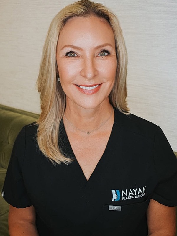 Smiling woman in black medical scrubs.