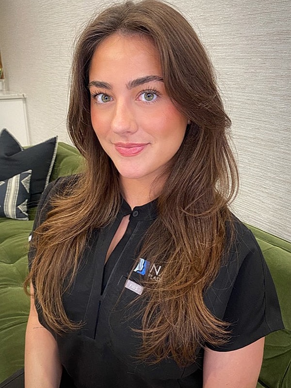 Woman with long hair smiling in professional attire.
