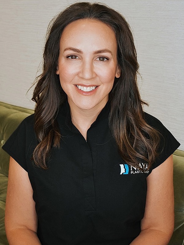 Smiling woman in professional medical attire.