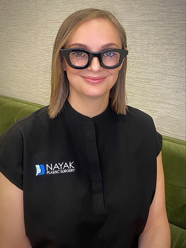 Professional woman in black with glasses.