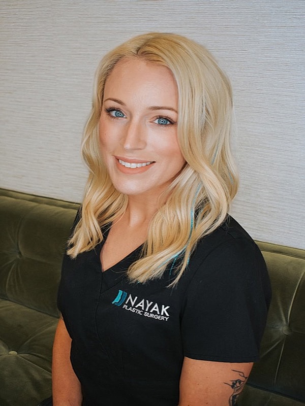 Smiling woman in medical attire at Nayak clinic.