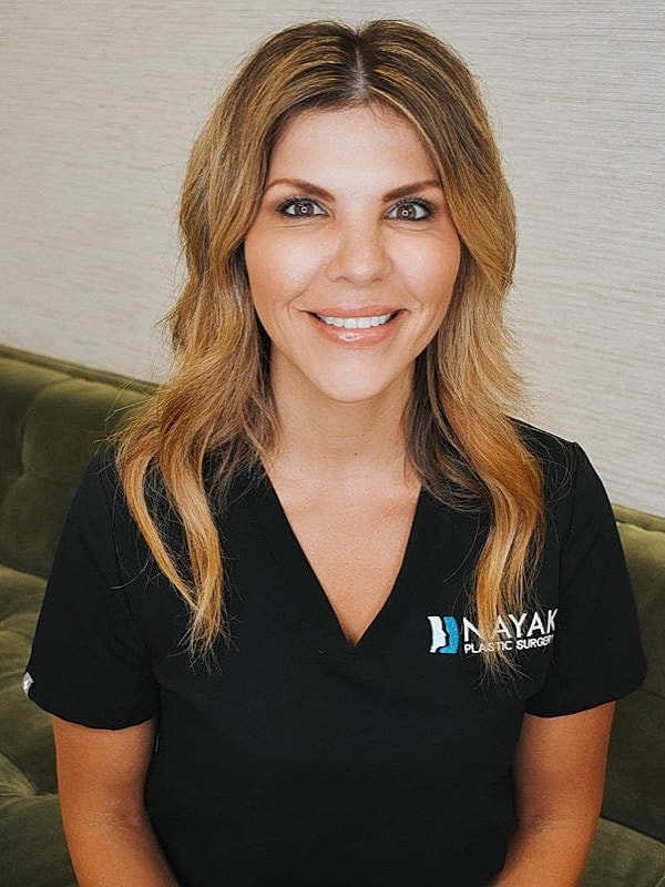 Woman smiling in medical uniform, indoors.