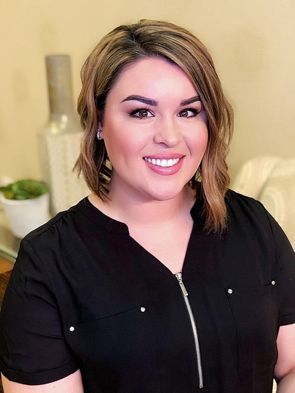 Smiling woman with medium-length hair indoors.