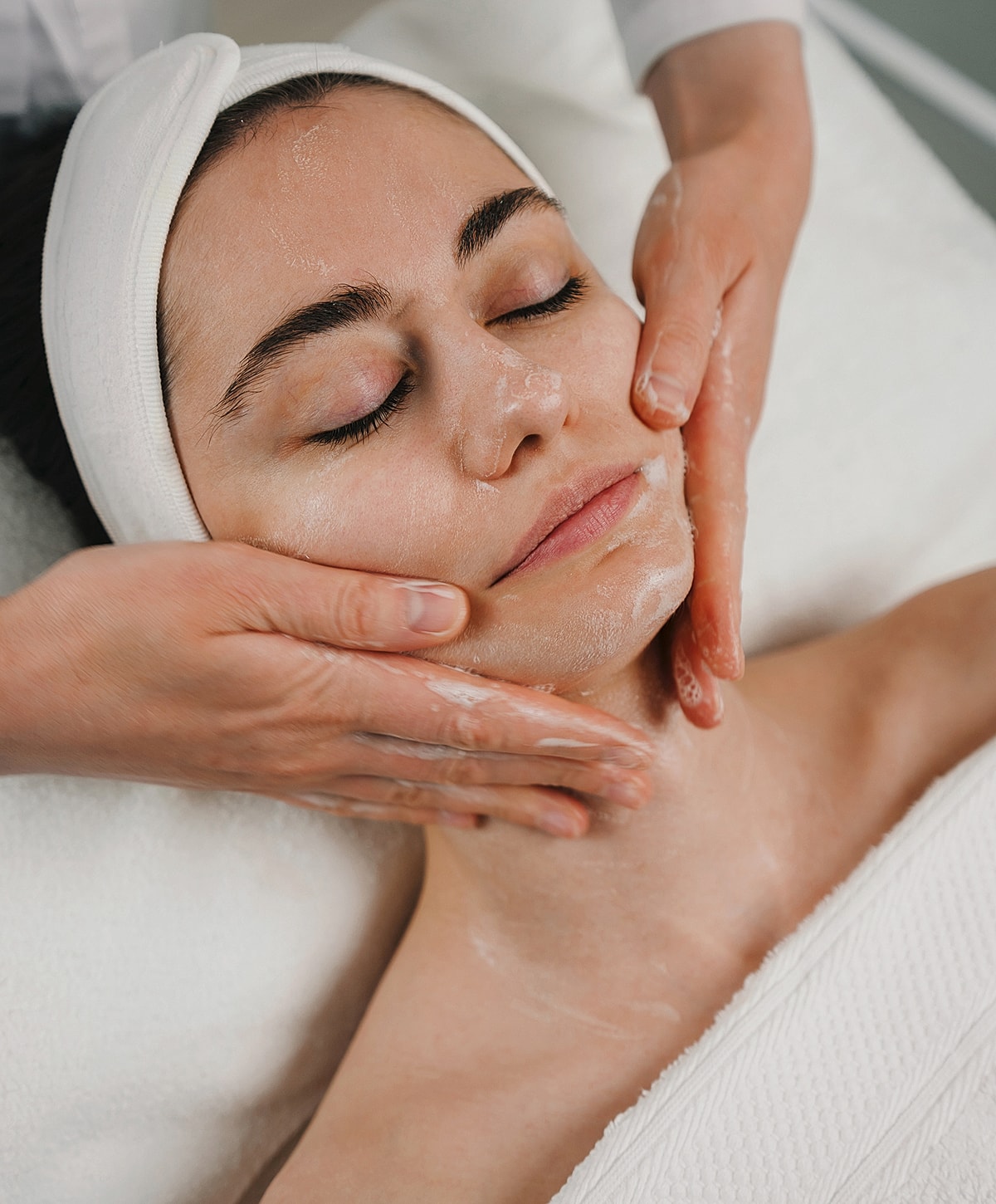 St. Louis Facial model receiving a facial treatment in spa.