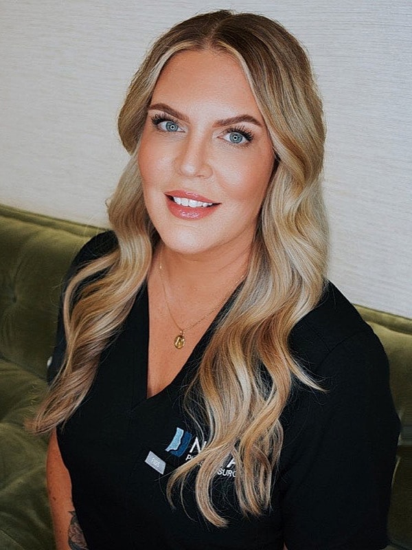 Smiling woman with long blonde hair in uniform.