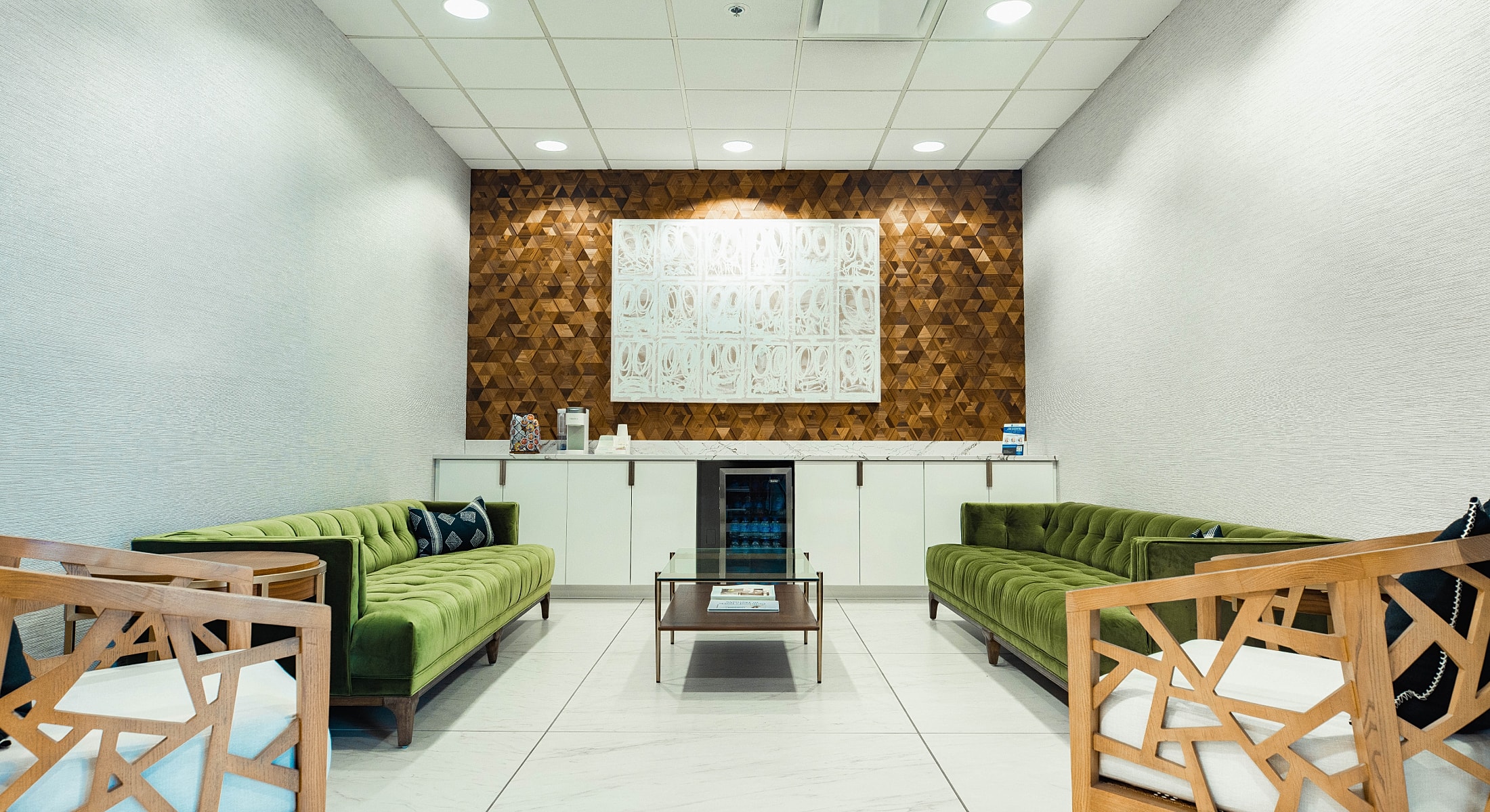 Modern waiting area with stylish green sofas.