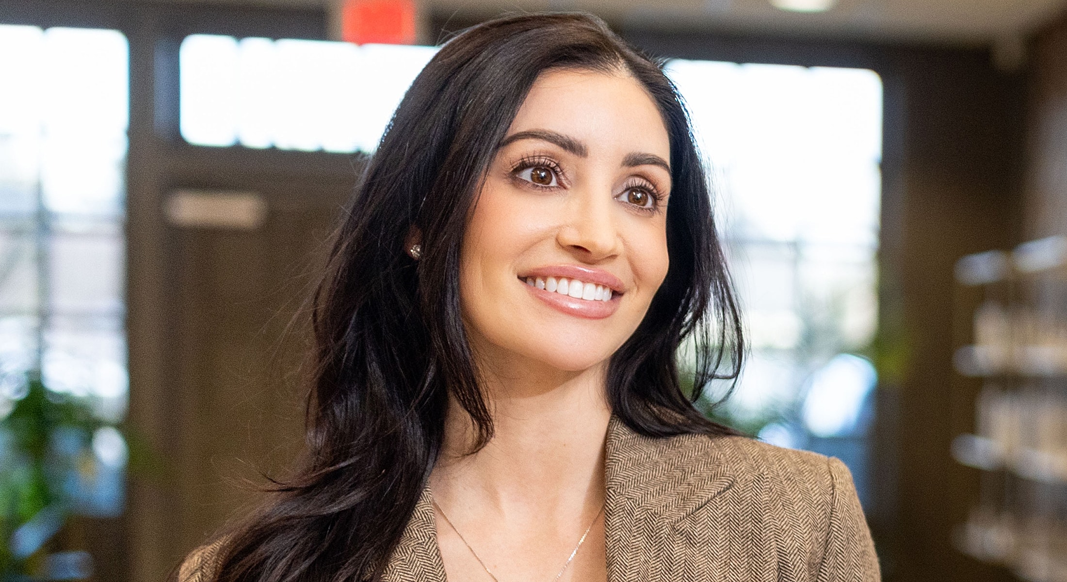Smiling woman in professional attire indoors.